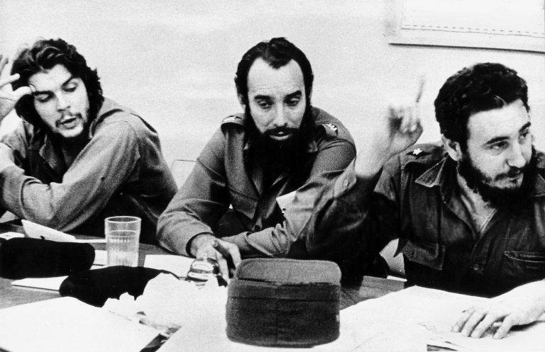 Esta foto de archivo de 1960 muestra al héroe de la Revolución Cubana Ernesto "Che" Guevara (izq.) y al capitán Antonio Núñez Jiménez (centro) escuchando a Fidel Castro (der.) durante una reunión de trabajo en La Habana. Núñez Jiménez, quien fue ayudante personal de Guevara durante los primeros años de la revolución y trabajó estrechamente con Fidel Castro antes de la misma, falleció el 14 de septiembre en La Habana a los 75 años a causa de un infarto, según informaron sus familiares.  (Foto de AFP)