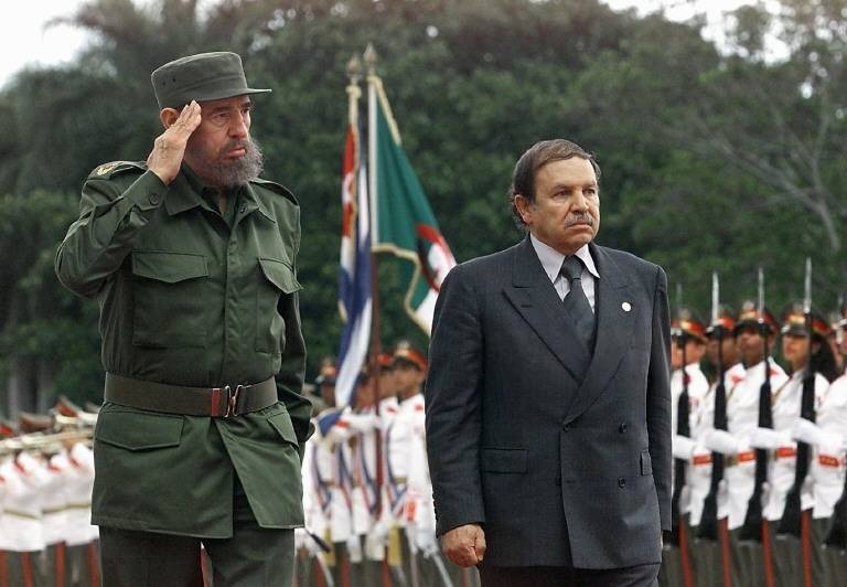 El presidente cubano Fidel Castro (izq.) y Abdelaziz Bouteflika (der.), presidente de Argelia, saludan a las tropas en una ceremonia el 15 de abril de 2000, en La Habana, Cuba. Bouteflika realiza una visita oficial a Cuba tras la culminación de la Cumbre del Sur en la que participó. (IMAGEN ELECTRÓNICA) AFP FOTO/ Adalberto Roque (Foto de Adalberto ROQUE / AFP)