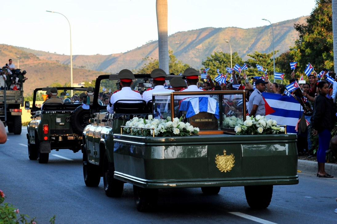 Cubanos presencian el paso de la urna con las cenizas del líder cubano Fidel Castro desde la Plaza de la Revolución en Santiago, Cuba, el 4 de diciembre de 2016, en su camino hacia el cementerio. Las cenizas del fallecido líder cubano Fidel Castro fueron trasladadas el domingo para recibir sepultura en un cementerio de la ciudad oriental de Santiago de Cuba. (Foto de YAMIL LAGE / AFP)