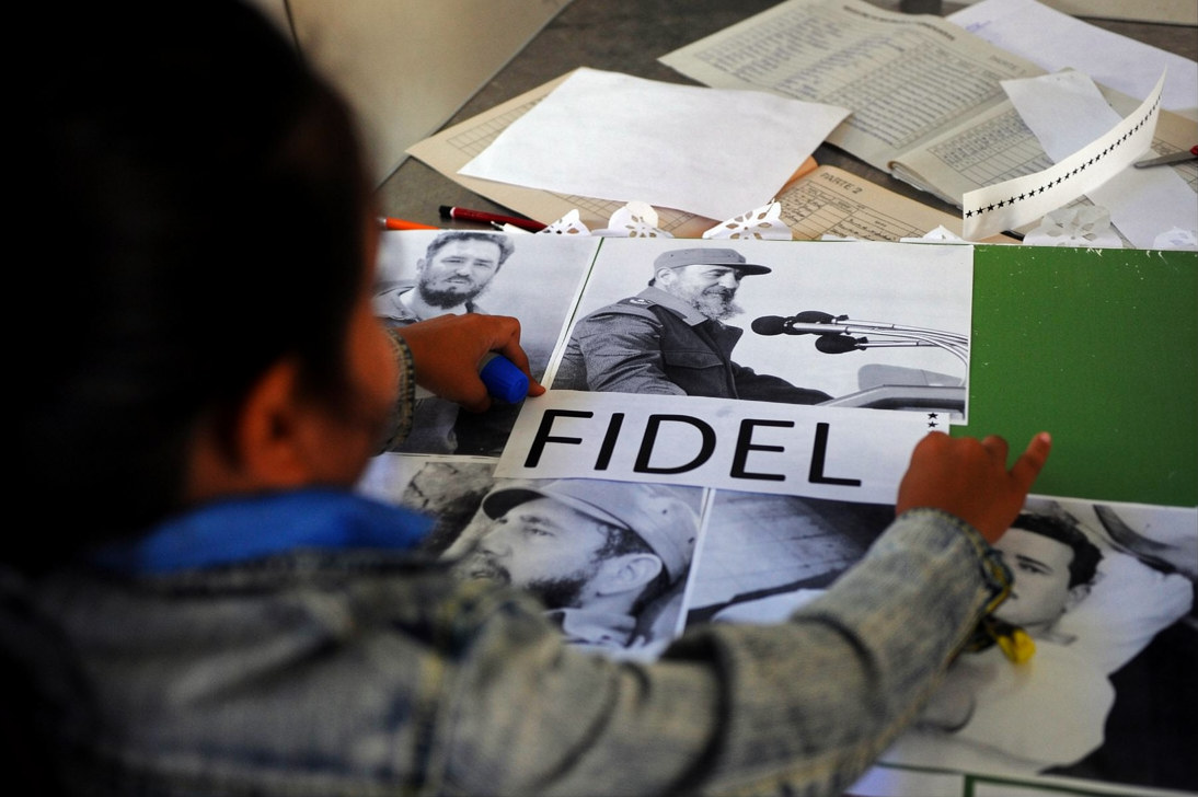 Un estudiante de primaria cubano trabaja en un collage con imágenes del fallecido líder cubano Fidel Castro en La Habana, el 23 de noviembre de 2017. (Foto de YAMIL LAGE / AFP)