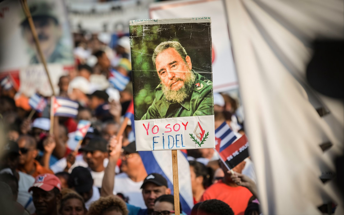 Se observa un cartel con la imagen del fallecido líder cubano Fidel Castro entre la multitud durante el acto del Primero de Mayo en la Plaza de la Revolución de La Habana, el 1 de mayo de 2018. (Foto de Yamil LAGE / AFP)
