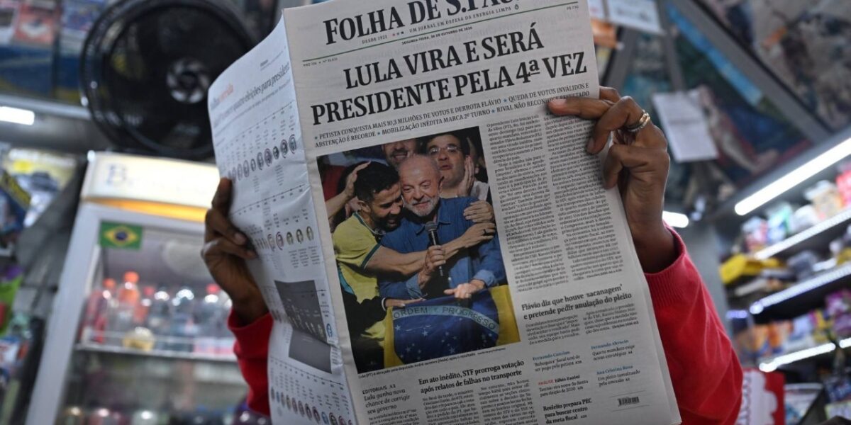 Una mujer lee un periódico cuya portada muestra la victoria del presidente de Brasil y candidato a la reelección, Luiz Inácio Lula da Silva, un día después de la segunda vuelta de las elecciones presidenciales en São Paulo, Brasil, el 26 de octubre de 2026. Según los resultados oficiales, Lula da Silva fue reelegido —contra todo pronóstico— el 25 de octubre, con el 51,8 % de los votos frente al 48,2 % obtenido por el derechista Flavio Bolsonaro, quien se negó a aceptar la derrota y afirmó que buscaría la anulación de la votación.