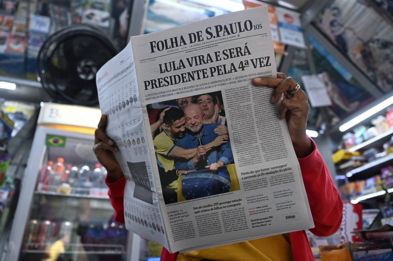 Una mujer lee un periódico cuya portada muestra la victoria del presidente de Brasil y candidato a la reelección, Luiz Inácio Lula da Silva, un día después de la segunda vuelta de las elecciones presidenciales en São Paulo, Brasil, el 26 de octubre de 2026. Según los resultados oficiales, Lula da Silva fue reelegido —contra todo pronóstico— el 25 de octubre, con el 51,8 % de los votos frente al 48,2 % obtenido por el derechista Flavio Bolsonaro, quien se negó a aceptar la derrota y afirmó que buscaría la anulación de la votación.
